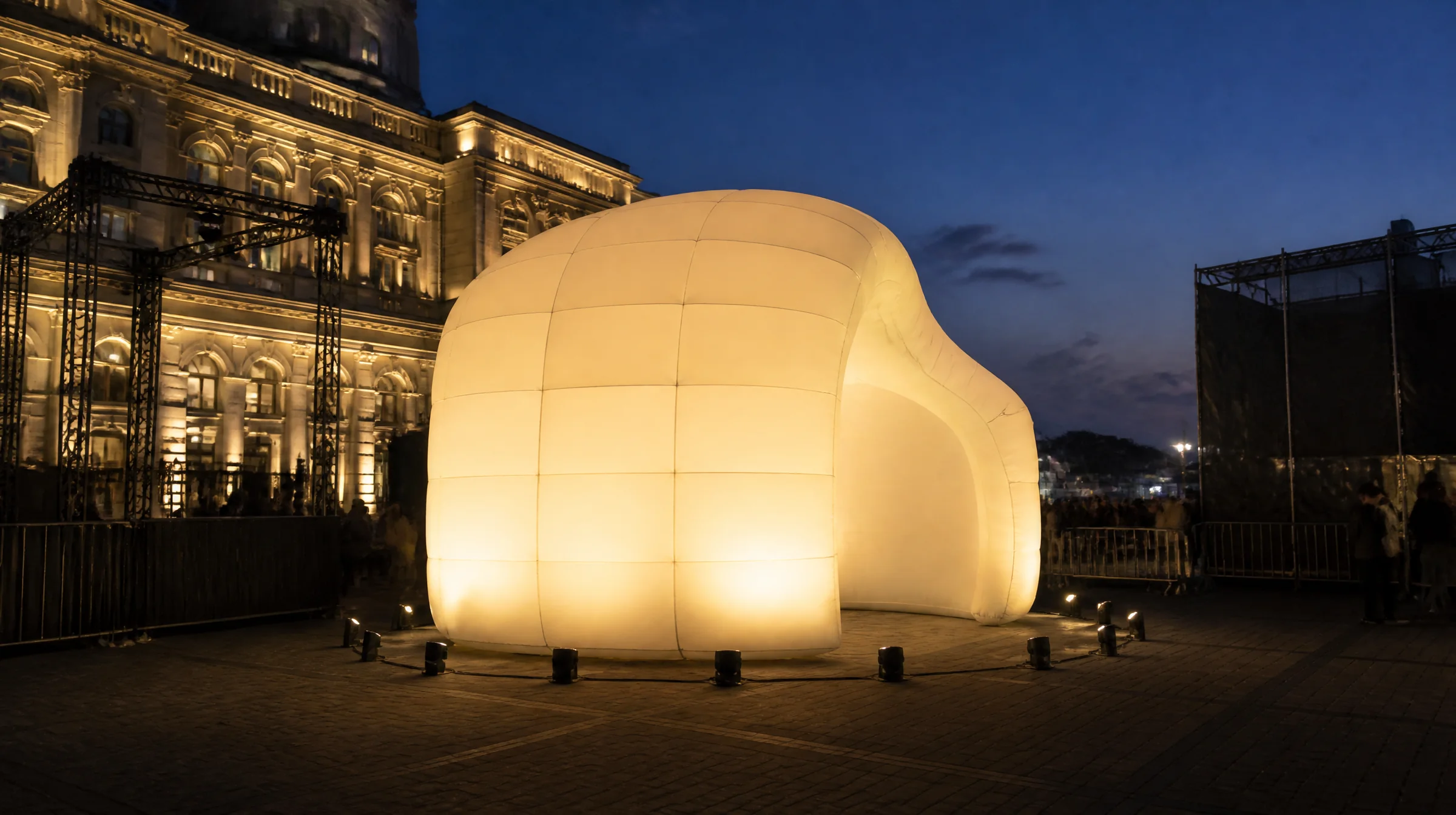 Large unbranded inflatable installation with subtle illumination in a realistic evening event environment.