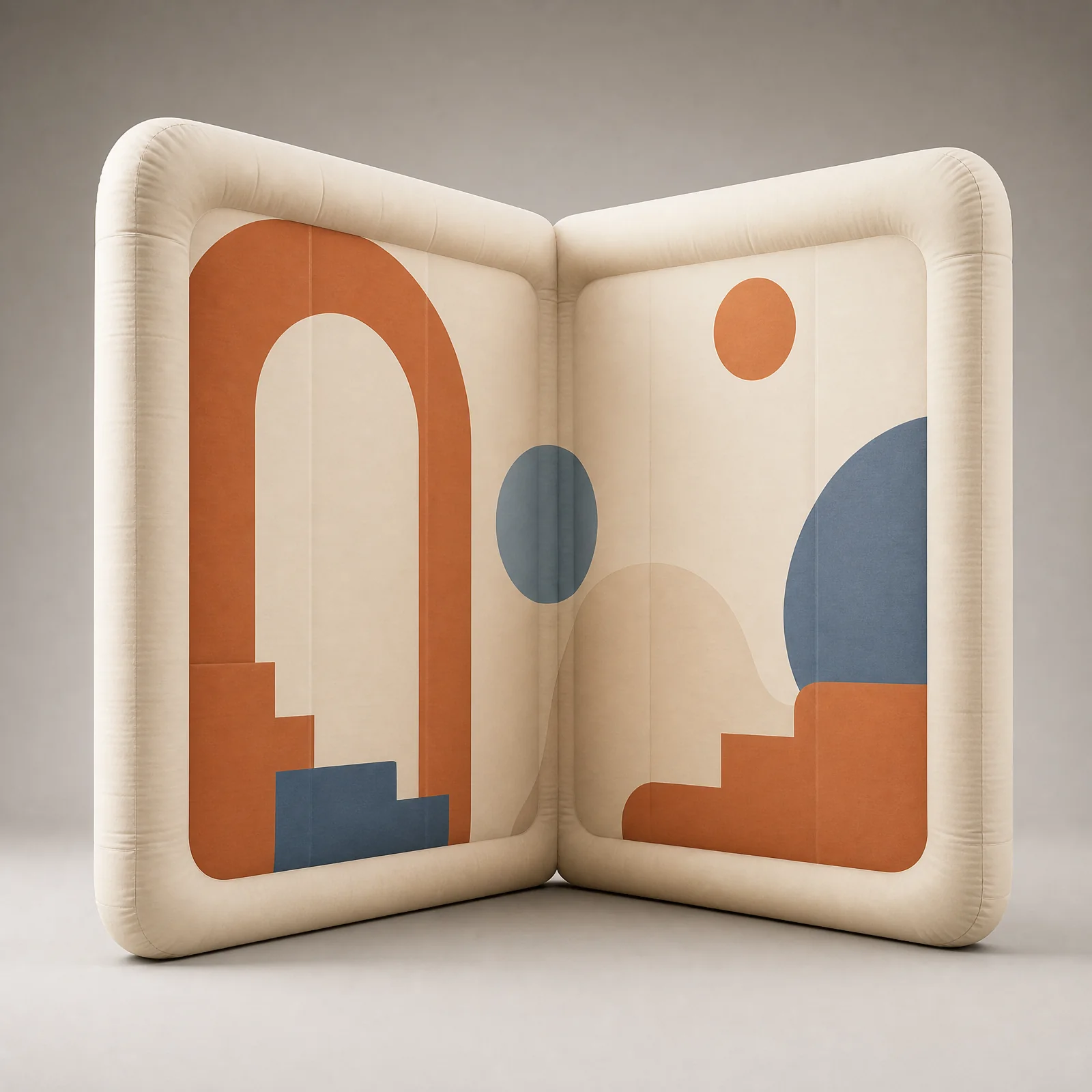 Two connected ivory inflatable backdrop panels forming a shallow open corner with terracotta and blue graphics