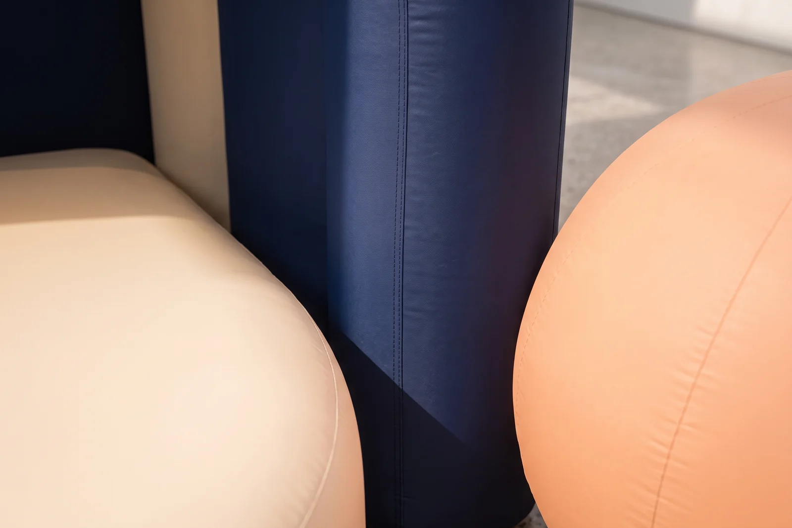 Close view of curved navy, cream, and coral inflatable display surfaces and seams.