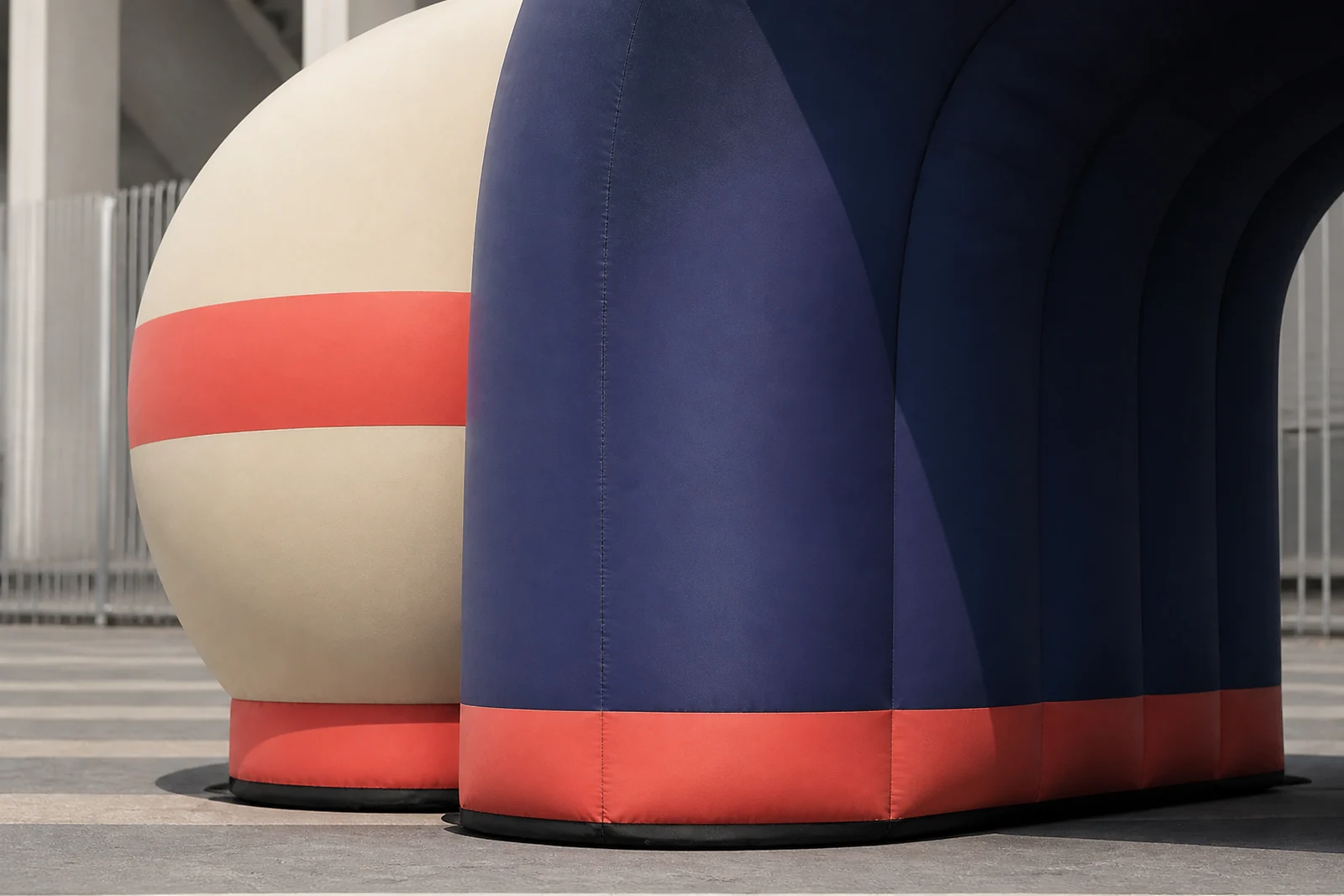 Close view of navy, coral, and cream inflatable expo booth columns and grounded base.